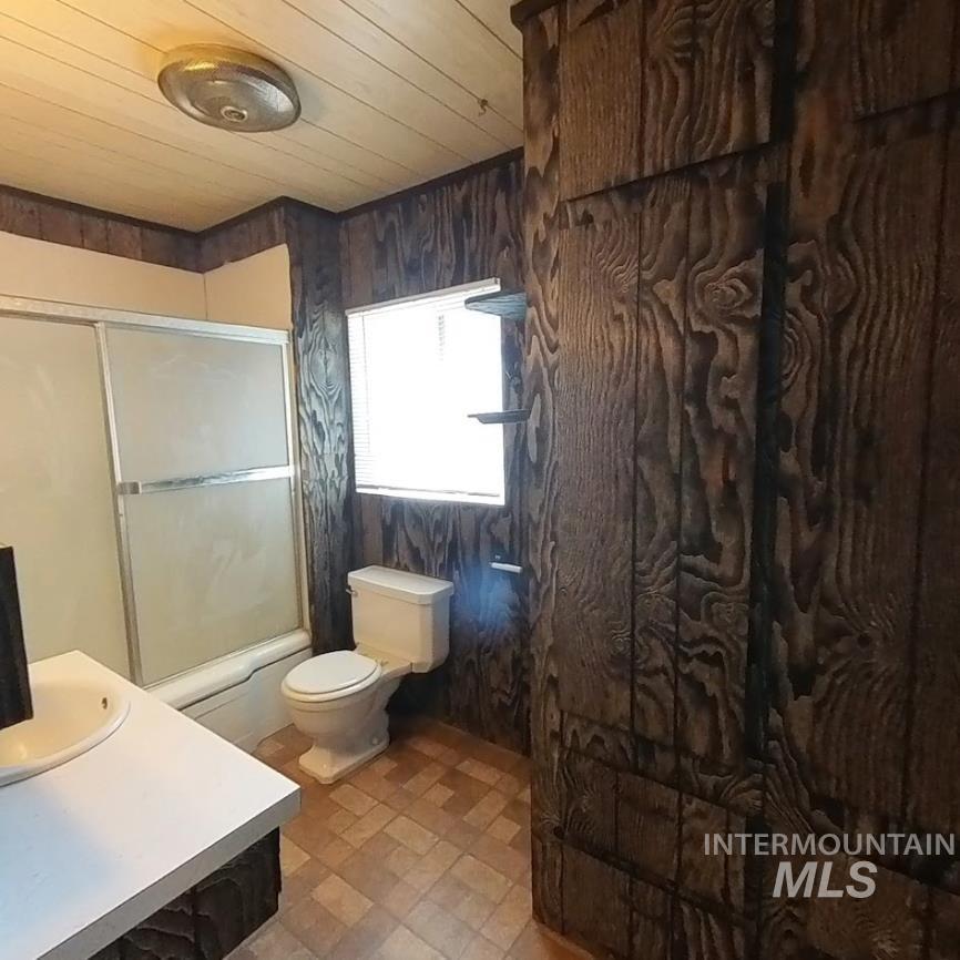 418 13th Street Clarkston, WA 99403 - Photo 12 of 26 Full bath with enclosed tub / shower combo, vanity, wood ceiling, and wood walls