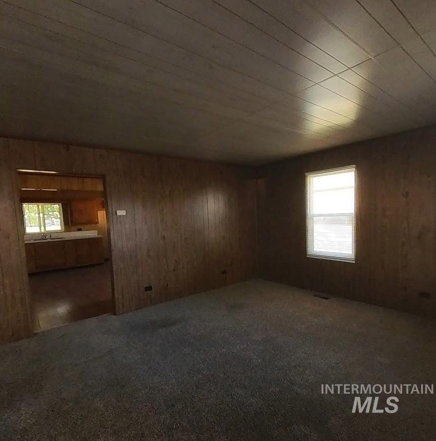 418 13th Street Clarkston, WA 99403 - Photo 19 of 26 Spare room featuring wooden walls and dark colored carpet