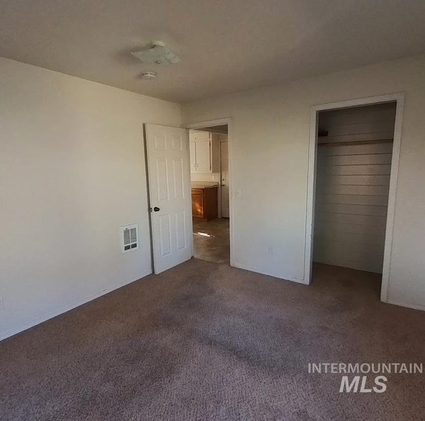 418 13th Street Clarkston, WA 99403 - Photo 21 of 26 Unfurnished bedroom with dark colored carpet and a closet