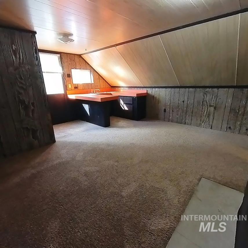 418 13th Street Clarkston, WA 99403 - Photo 9 of 26 Additional living space with wooden walls, lofted ceiling, and carpet