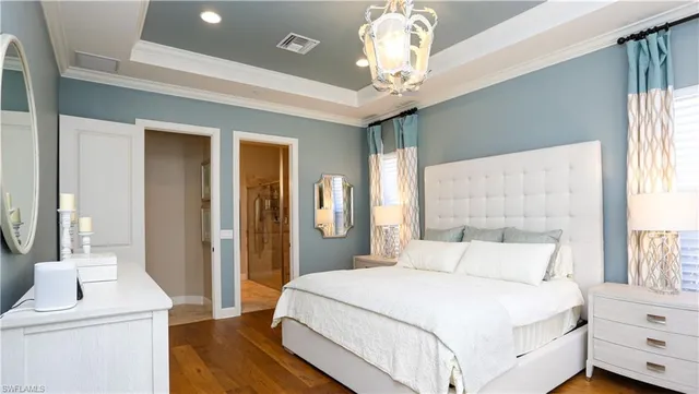 a bedroom with a large bed and a chandelier