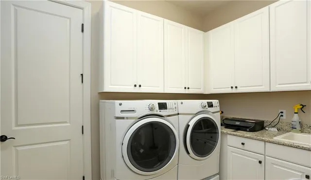 a utility room with sink dryer and washer