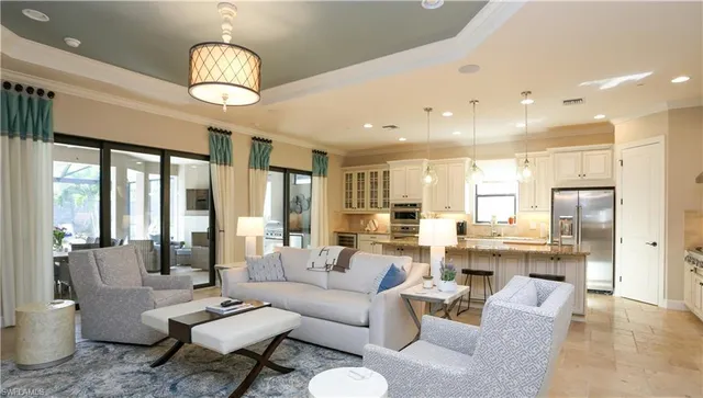 a living room with furniture kitchen view and a large window