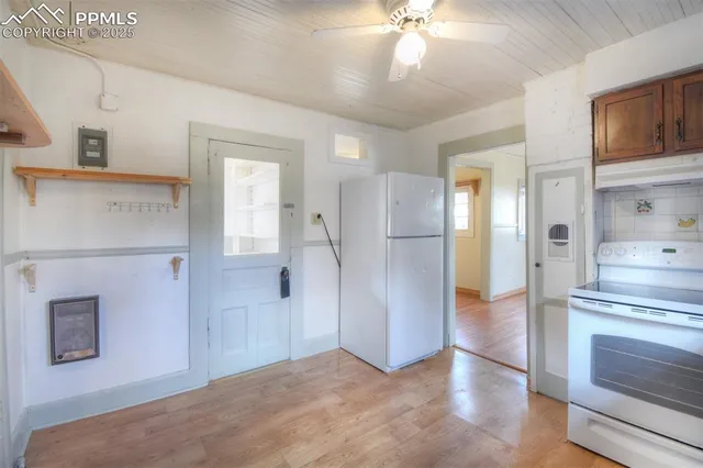 a view of a kitchen with a stove cabinets a ceiling fan and wooden floor