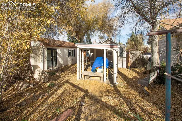 a view of a patio with table and chairs near a large tree
