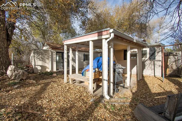 a view of a patio with a table and chairs a barbeque with wooden fence