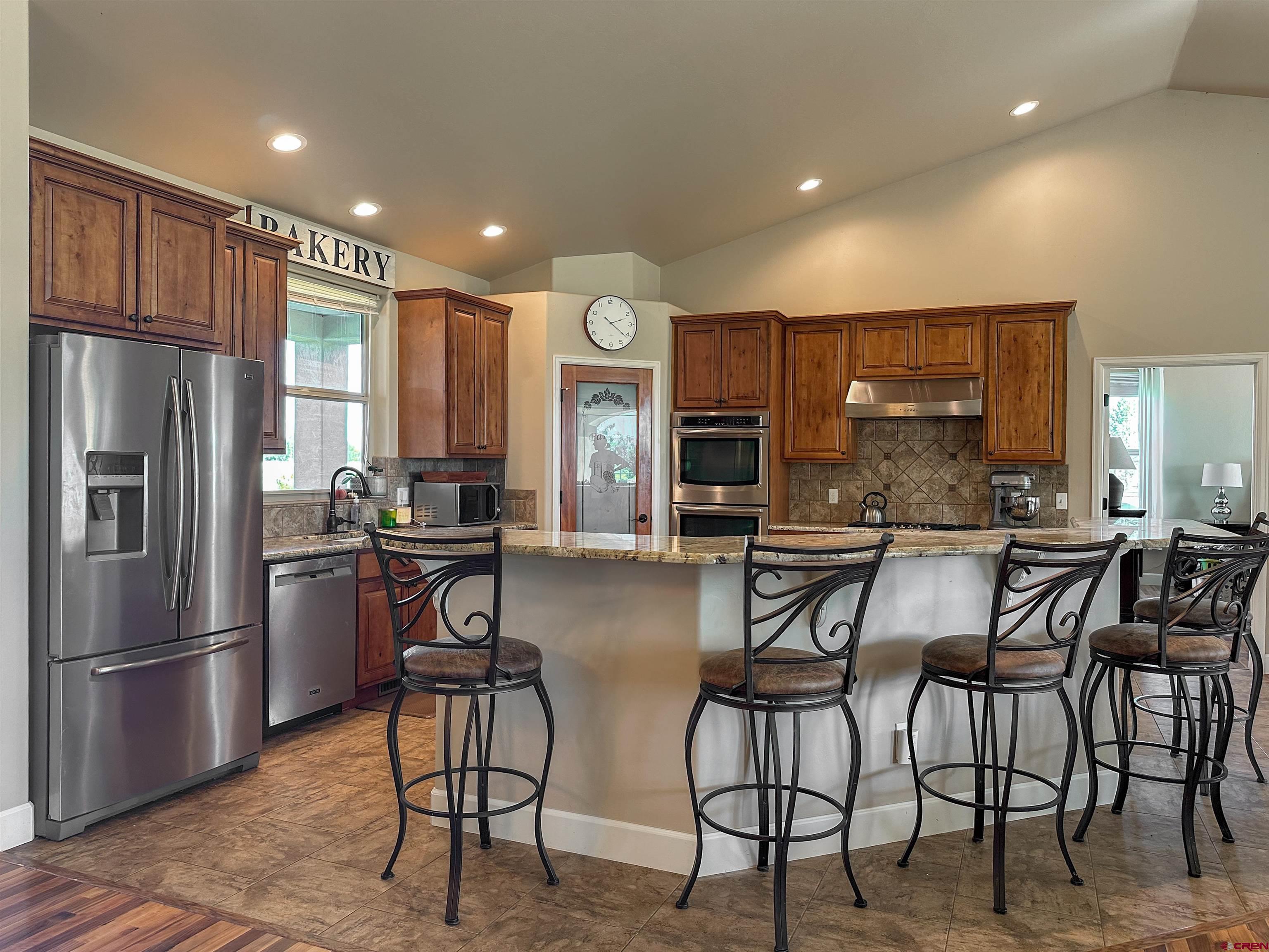 424 Shilo Court Delta, CO 81416 - Photo 15 of 45 a kitchen with stainless steel appliances kitchen island granite countertop a refrigerator and cabinets