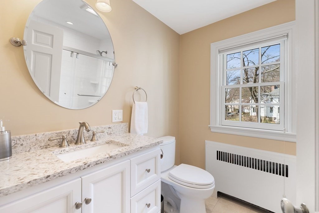 15 Gould Road Newton, MA 02468 - Photo 27 of 33 a bathroom with a granite countertop toilet a sink and a mirror