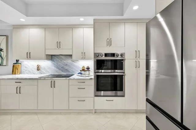 a kitchen with stainless steel appliances granite countertop a refrigerator and a stove