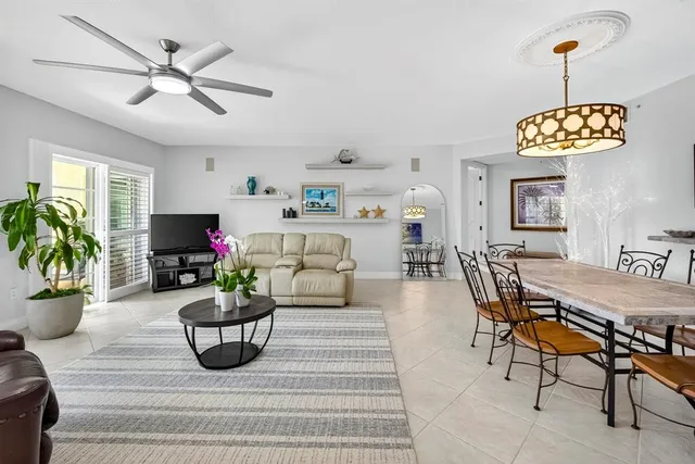 a living room with furniture kitchen view and a chandelier