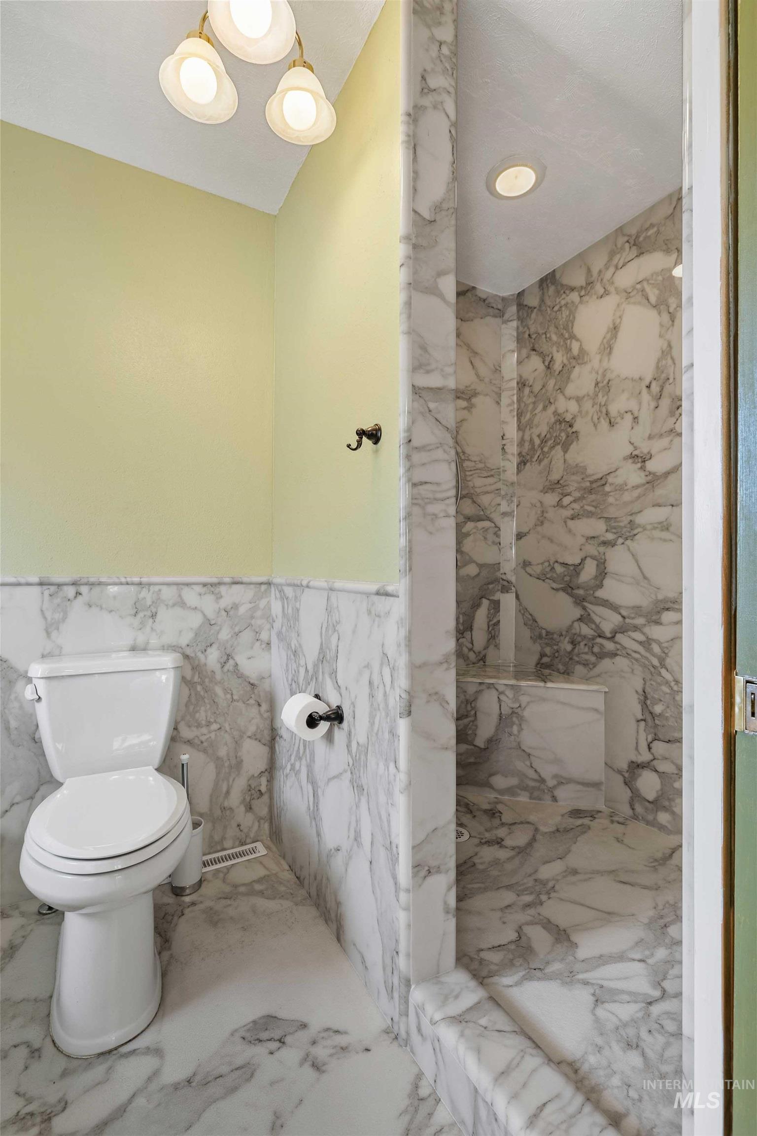 415 West 300 South Heyburn, ID 83336 - Photo 15 of 50 Bathroom featuring tile walls, marble finish floors, a marble finish shower, wainscoting, and recessed lighting