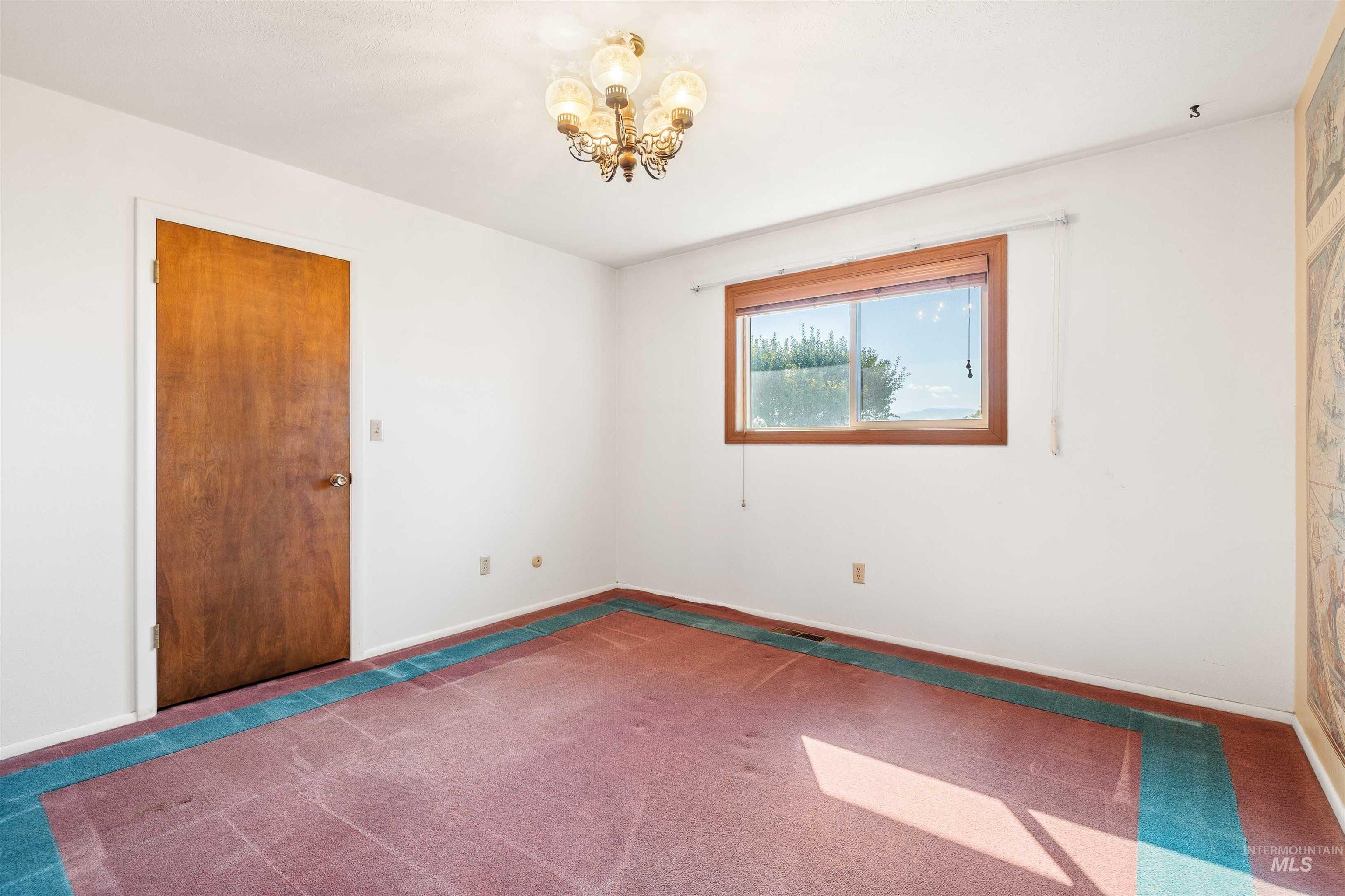 415 West 300 South Heyburn, ID 83336 - Photo 18 of 50 Carpeted spare room featuring a chandelier and baseboards