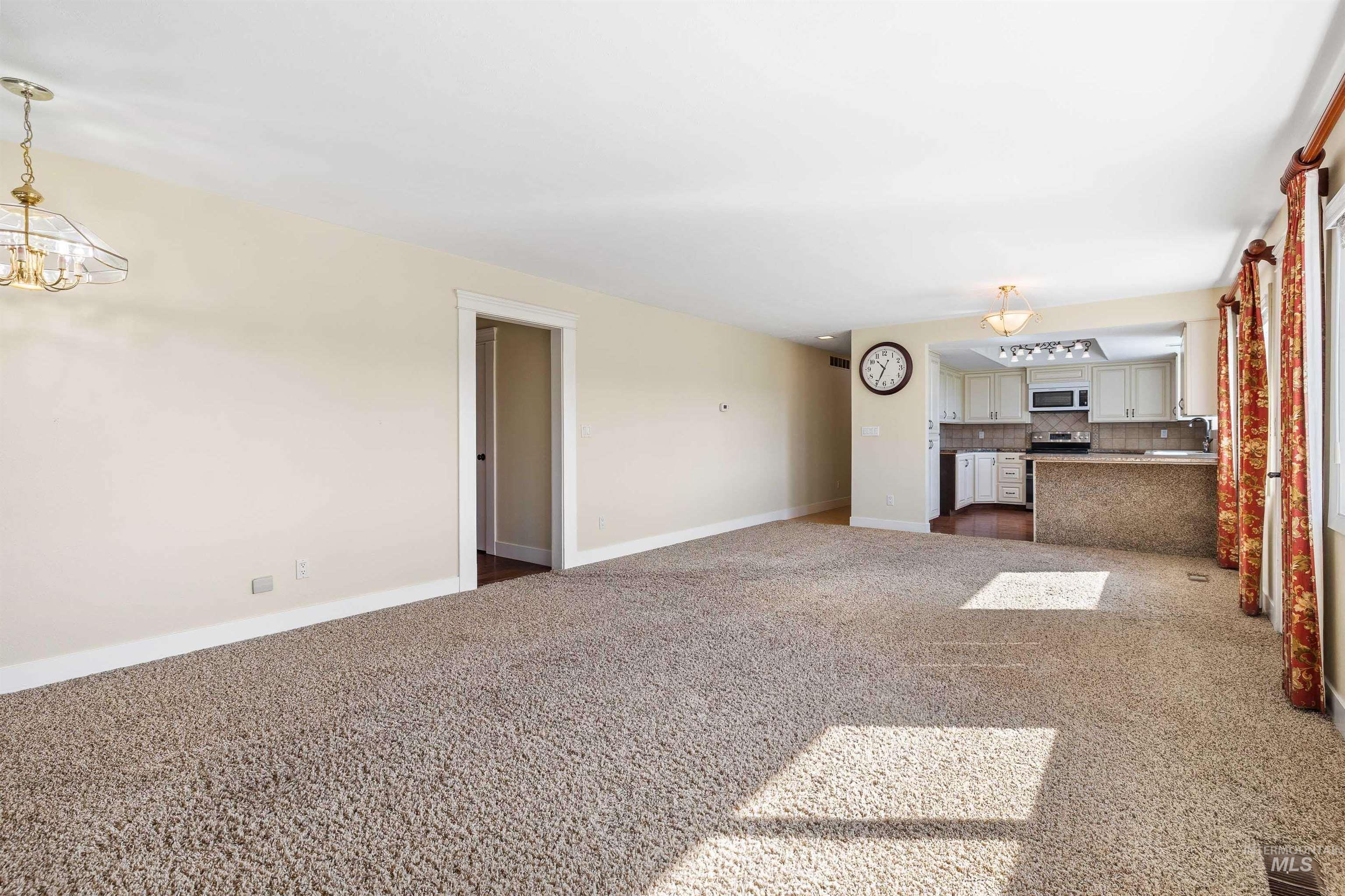 415 West 300 South Heyburn, ID 83336 - Photo 9 of 50 Unfurnished living room featuring dark carpet and a chandelier