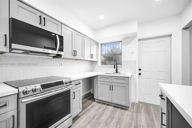 a kitchen with a sink stove and microwave
