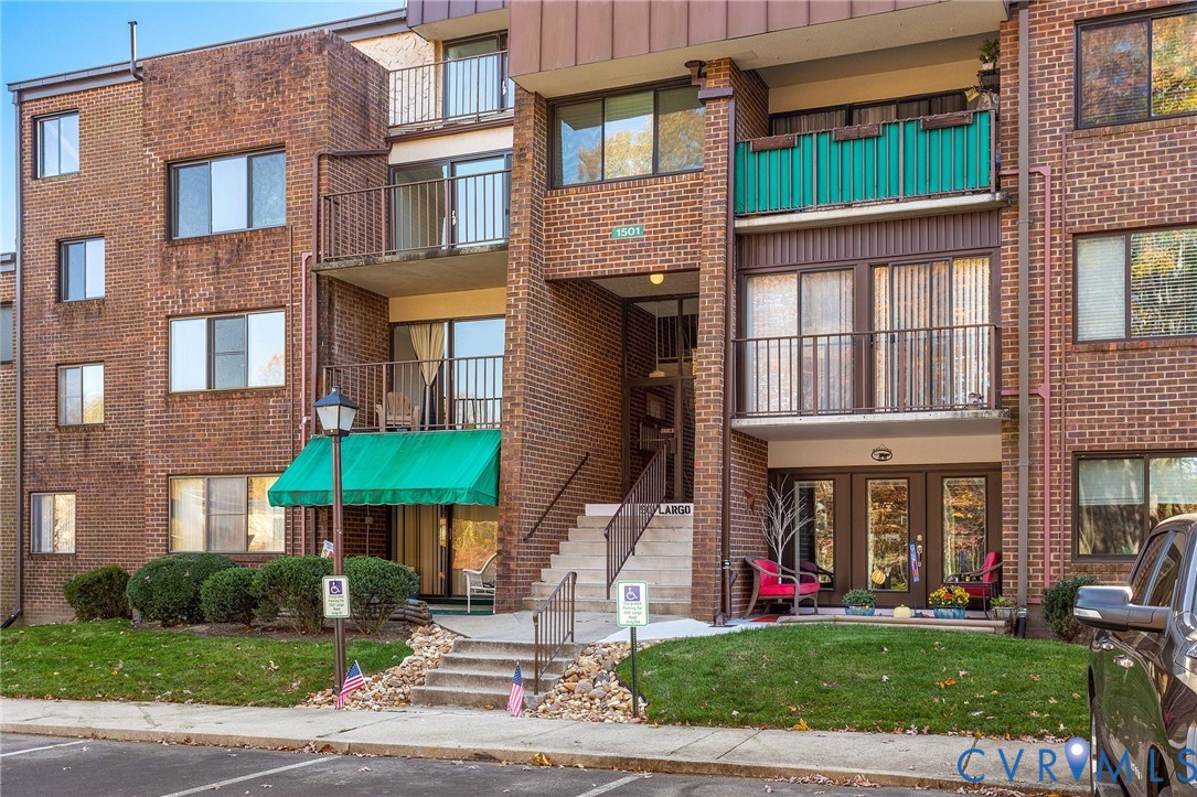 a front view of a brick building with many windows and yard