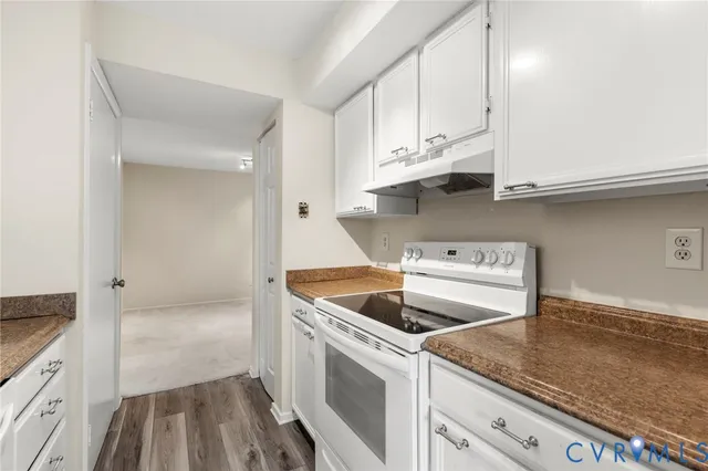 a kitchen with granite countertop white cabinets and white appliances