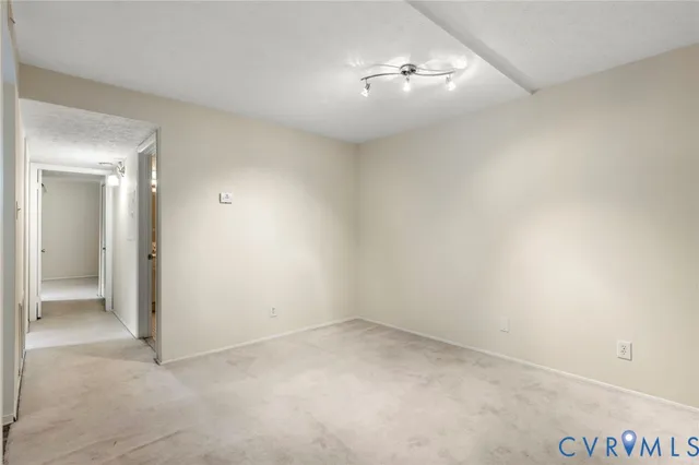 an empty room with a ceiling fan and a view of a bathroom