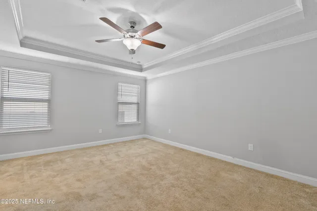 an empty room with a window and a ceiling fan