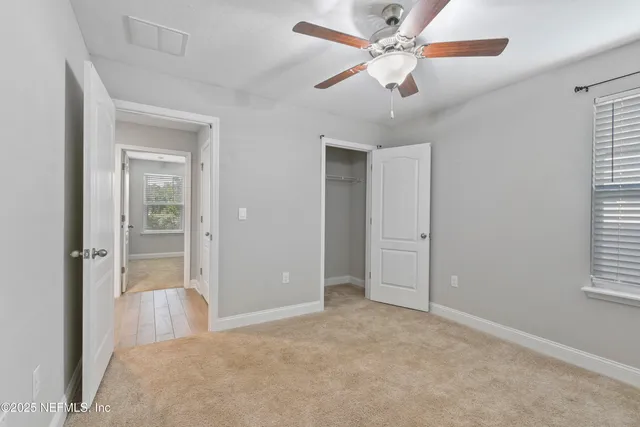 an empty room with chandelier fan