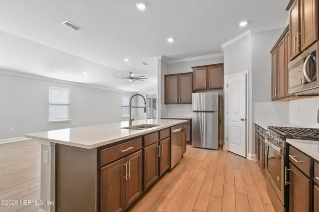 a kitchen with stainless steel appliances granite countertop a sink stove and refrigerator