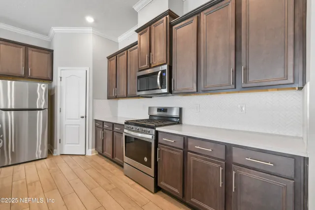 a kitchen with stainless steel appliances granite countertop a refrigerator stove and sink