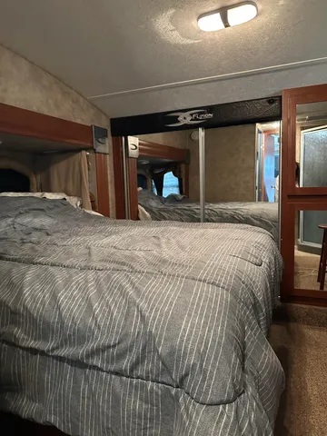 a large bed sitting in a bedroom next to a window