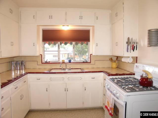799 Gear Street Reno, NV 89503 - Photo 4 of 9 a kitchen with granite countertop a stove a sink dishwasher and cabinets with wooden floor
