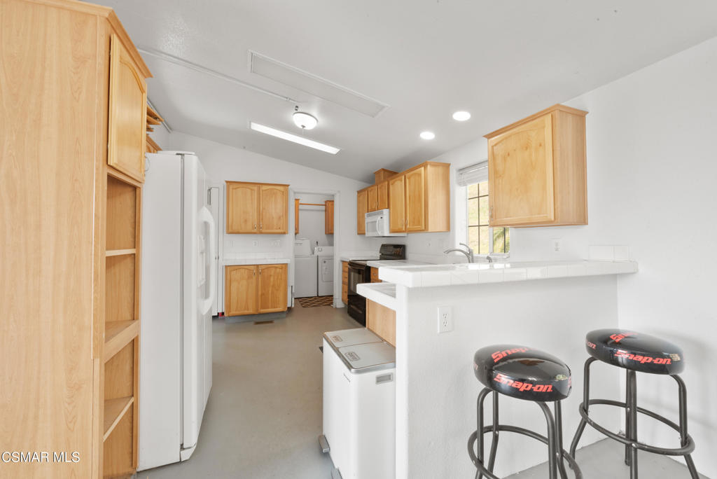 6079 Cedar Street Simi Valley, CA 93063 - Photo 6 of 31 a kitchen with stainless steel appliances kitchen island granite countertop a refrigerator and a stove top oven