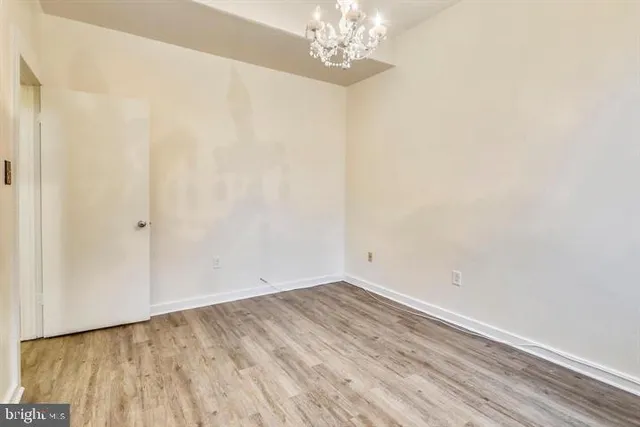 a view of a room with wooden floor and chandelier