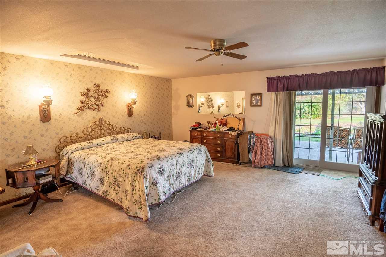 817 Rubio Way Gardnerville, NV 89460 - Photo 22 of 28 a spacious bedroom with a bed and a chandelier