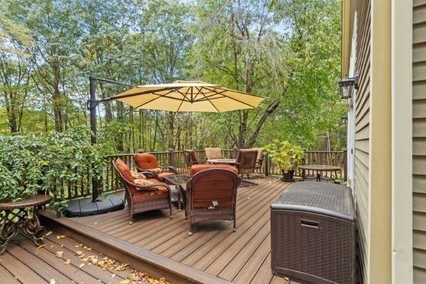 77 Teele Road Bolton, MA 01740 - Photo 33 of 41 a view of a roof deck with table and chairs under an umbrella