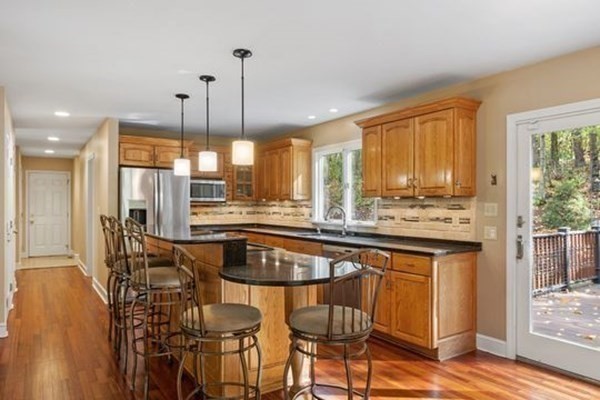 77 Teele Road Bolton, MA 01740 - Photo 10 of 41 a kitchen with stainless steel appliances kitchen island granite countertop a table chairs and a wooden floors