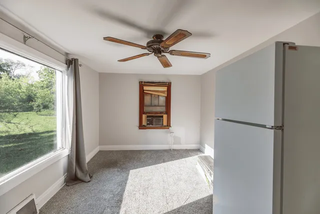 a view of a living room with a ceiling fan and a window