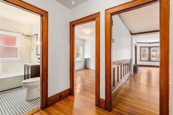 a view of a hallway with wooden floor and windows
