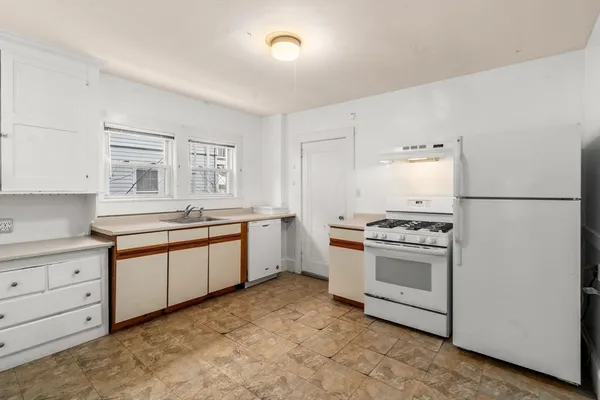 wooden floor fireplace and windows in an empty room