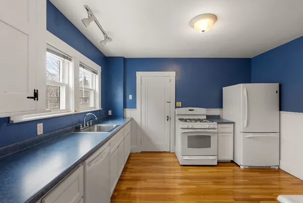 a kitchen with granite countertop wooden cabinets and white appliances
