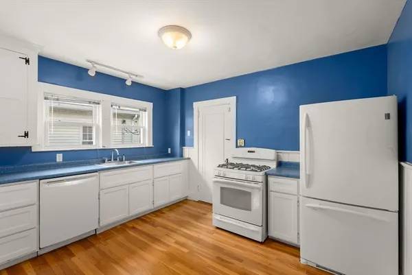 a view of a living room and kitchen with wooden floor