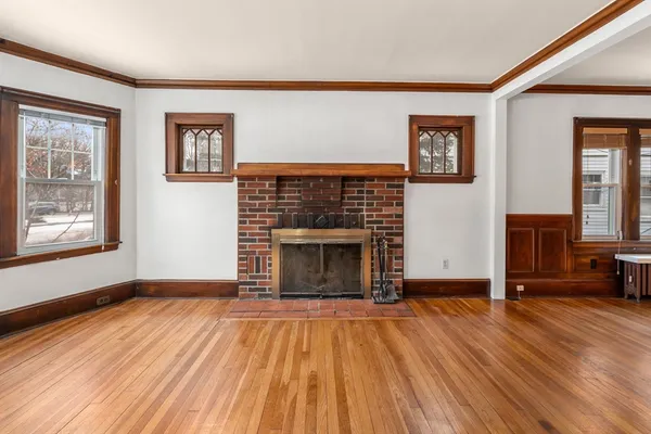 wooden floor fireplace and windows in an empty room