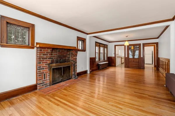 a view of a livingroom with wooden floor and a fireplace