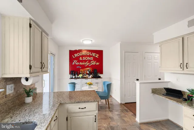 a kitchen with stainless steel appliances granite countertop white cabinets sink and large window