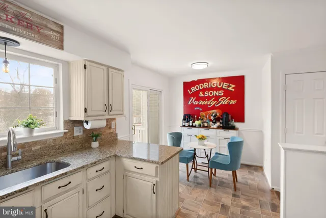 a kitchen with granite countertop a sink cabinets stainless steel appliances and a counter space