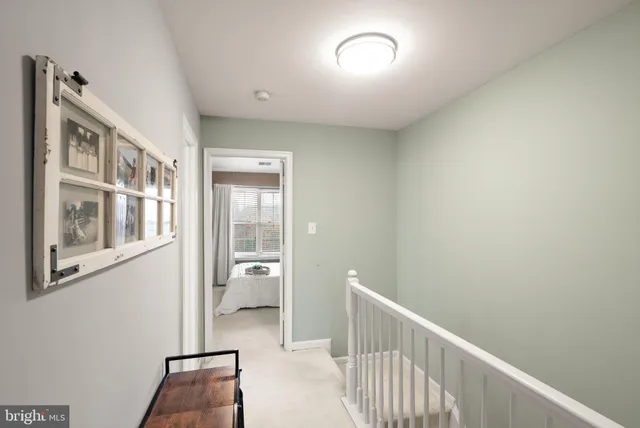 a white painted room with furniture and a chandelier fan