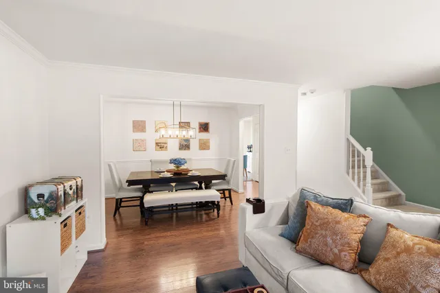 a dining room with furniture a chandelier and wooden floor