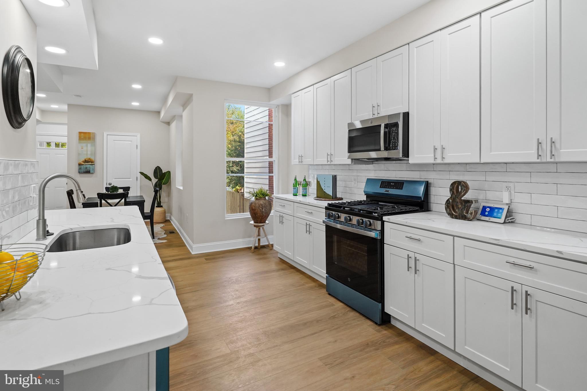 715 Longfellow Street Northwest Washington, DC 20011 - Photo 3 of 21 a kitchen with stainless steel appliances granite countertop a sink a stove and a refrigerator