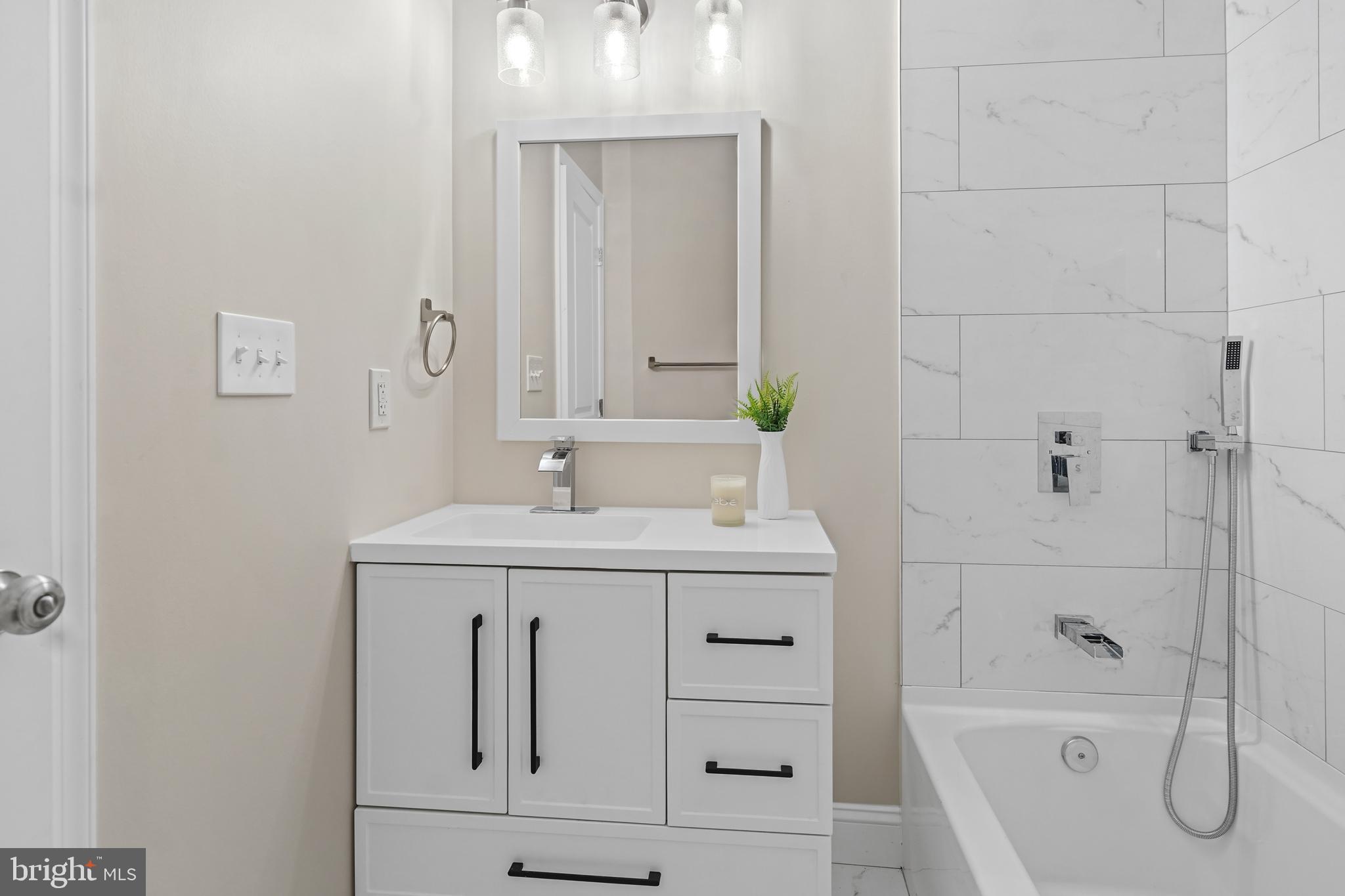 715 Longfellow Street Northwest Washington, DC 20011 - Photo 9 of 21 a bathroom with a bathtub sink vanity and mirror