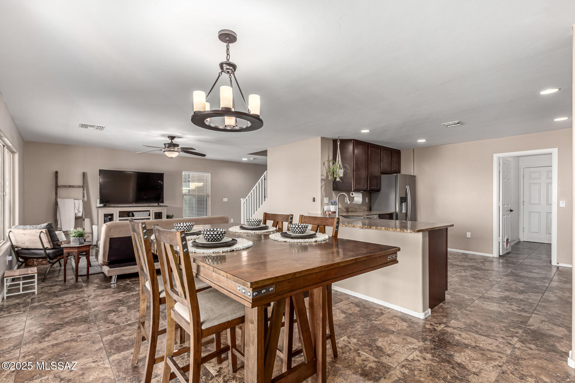 9528 Desert Fauna Loop Tucson, AZ 85747 - Photo 10 of 46 a dining room with stainless steel appliances kitchen island granite countertop a dining table chairs and a refrigerator