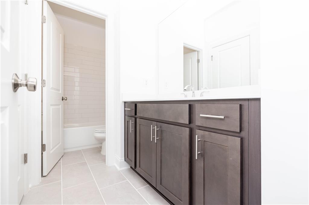 362 Olmstead Way, Unit 23 Alpharetta, GA 30022 - Photo 28 of 43 a bathroom with a granite countertop sink a toilet and shower