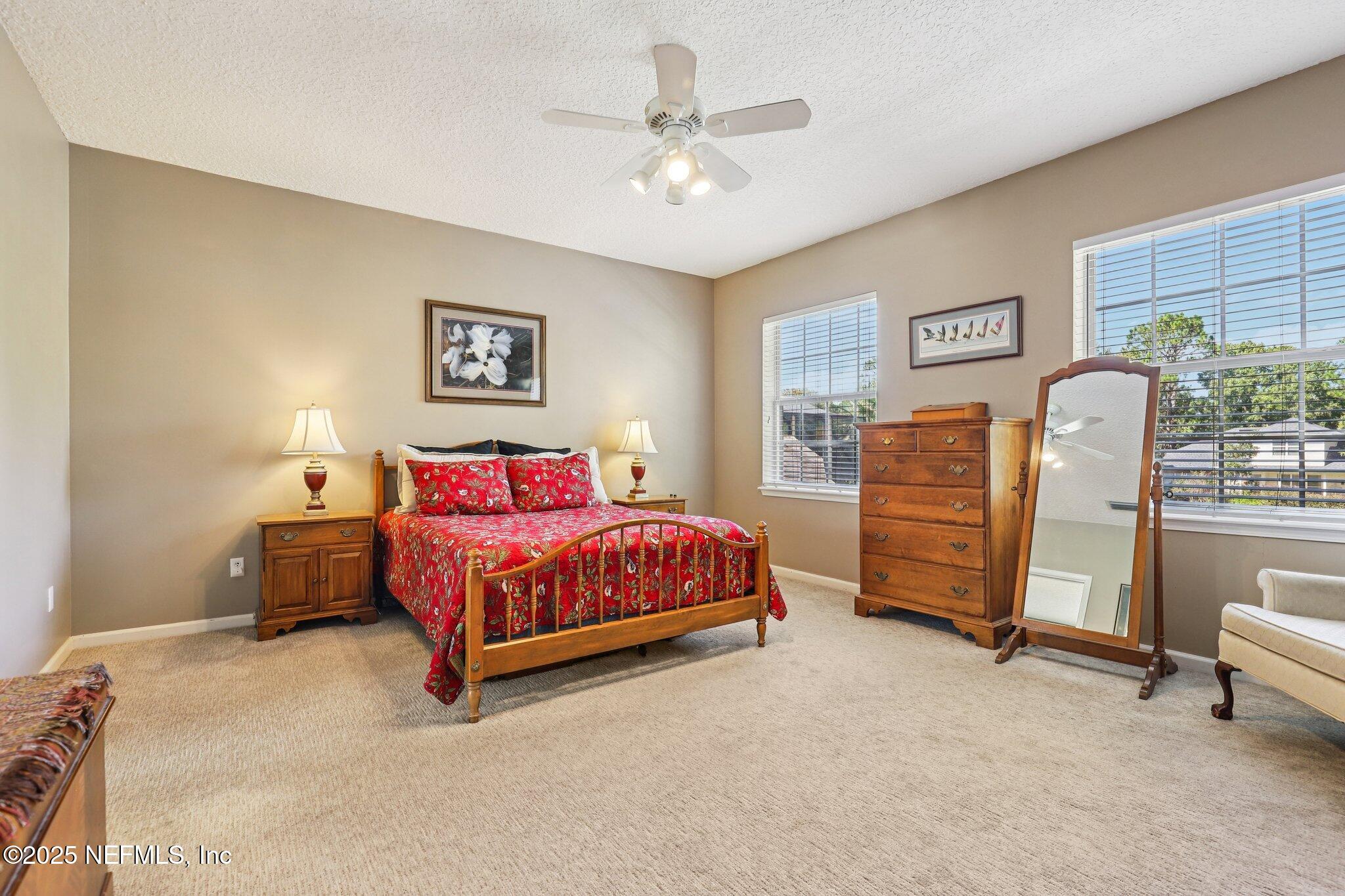 1432 Course View Drive Fleming Island, FL 32003 - Photo 12 of 83 a spacious bedroom with a bed and a chandelier