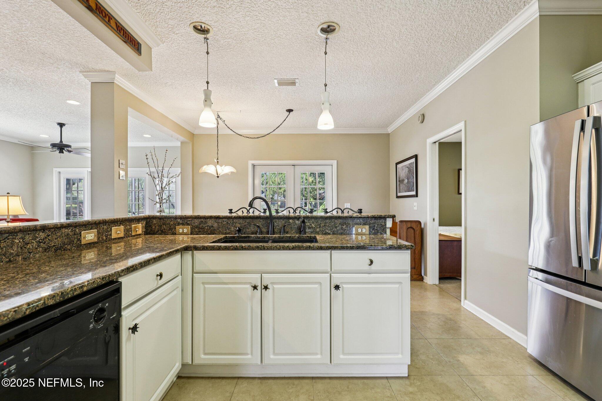 1432 Course View Drive Fleming Island, FL 32003 - Photo 32 of 83 a kitchen with granite countertop a sink a counter space appliances and cabinets