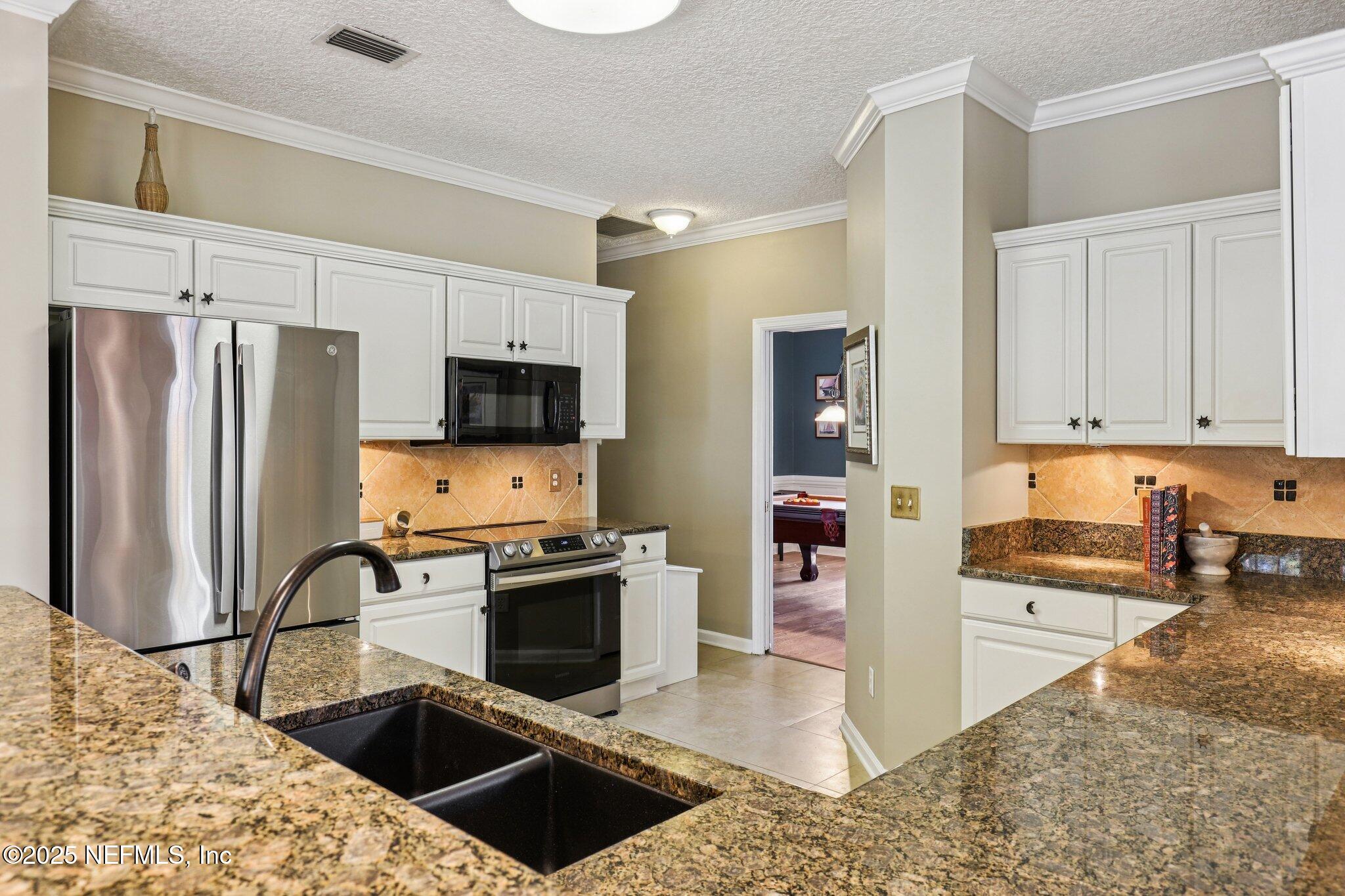1432 Course View Drive Fleming Island, FL 32003 - Photo 33 of 83 a kitchen with stainless steel appliances granite countertop a refrigerator stove and sink